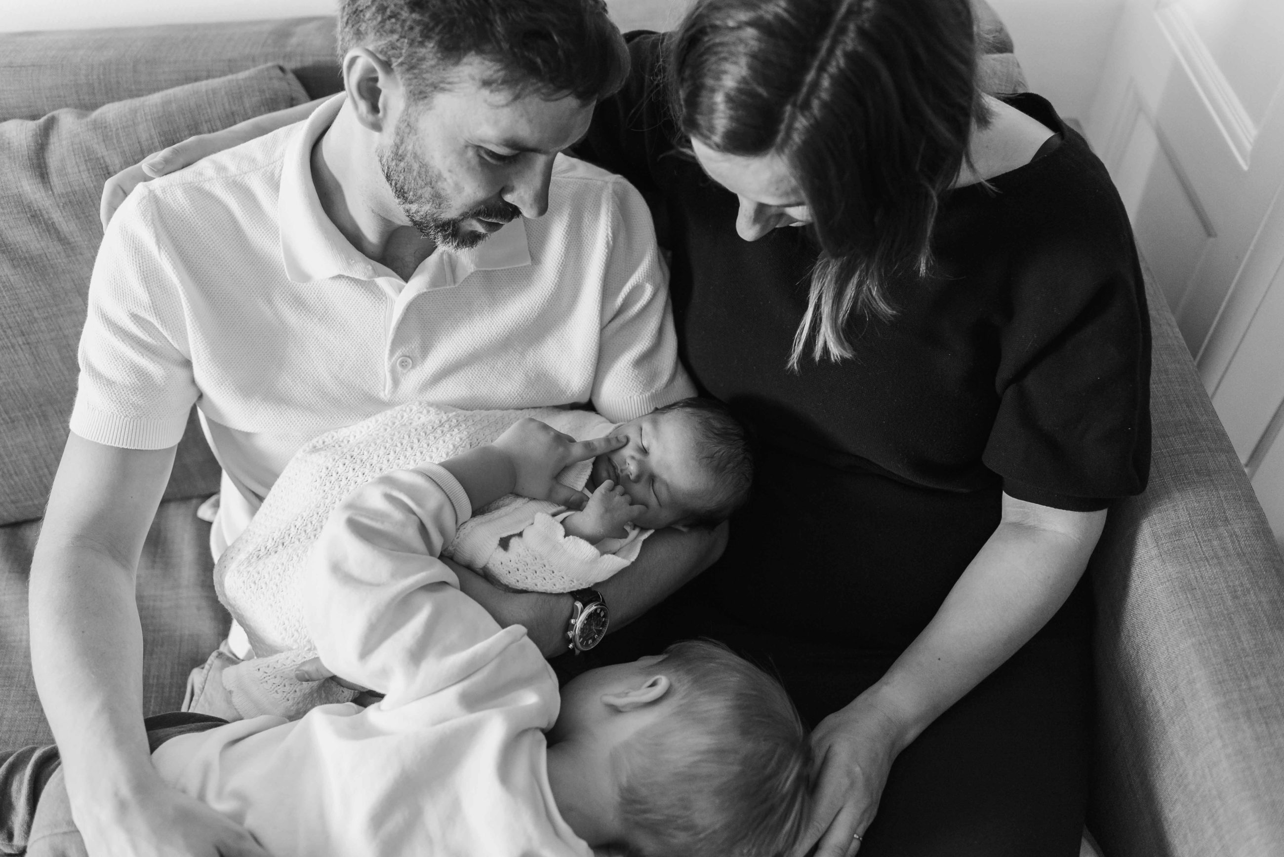 Eveliina, son mari et leurs deux enfants assis sur un canapé